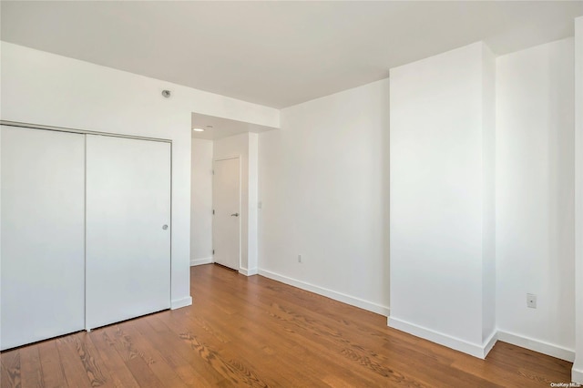 unfurnished bedroom featuring wood-type flooring and a closet