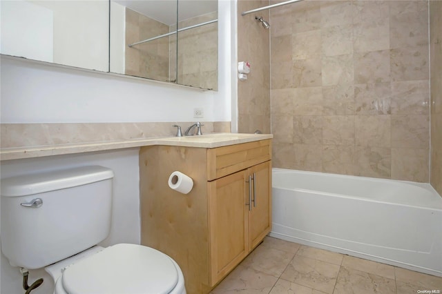 full bathroom featuring vanity, tiled shower / bath combo, and toilet