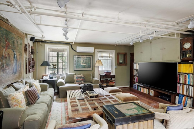 living room with a wall mounted air conditioner and hardwood / wood-style flooring