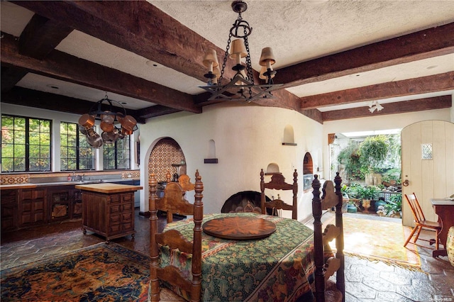 dining area with beam ceiling, plenty of natural light, and a notable chandelier