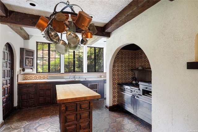 491 Muttontown Rd, Muttontown, NY 11791 - kitchen with wood counters, beam ceiling, a center island, and a textured wall