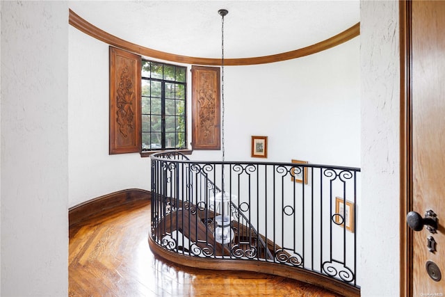 stairs featuring crown molding and a textured ceiling