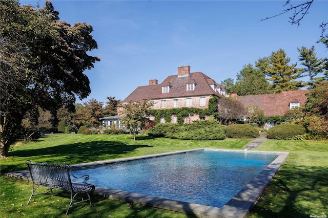 view of swimming pool with a yard