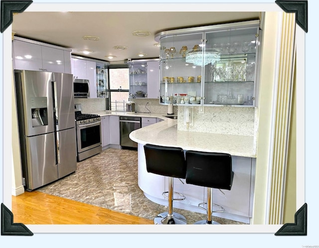 kitchen featuring appliances with stainless steel finishes, light hardwood / wood-style floors, white cabinetry, and sink