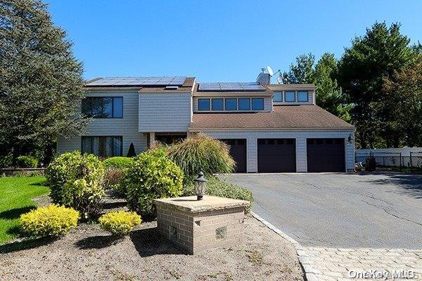 view of front of home featuring solar panels and a garage