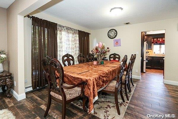 dining area with baseboard heating and dark wood-type flooring