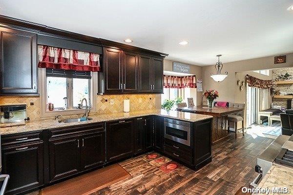 kitchen featuring decorative light fixtures, dark hardwood / wood-style flooring, sink, and a wealth of natural light