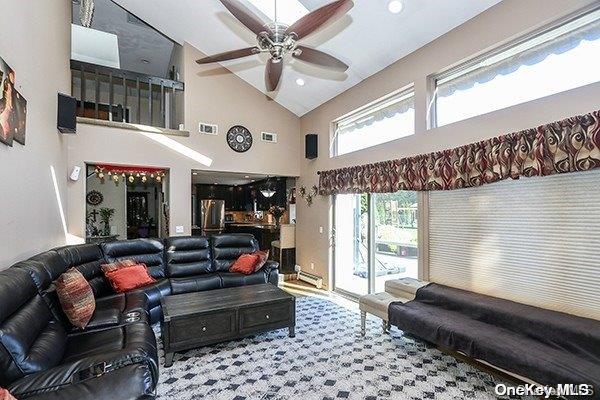 living room with carpet flooring, high vaulted ceiling, and ceiling fan