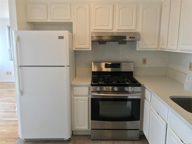 kitchen featuring white cabinetry, stainless steel range with gas cooktop, white fridge, and extractor fan