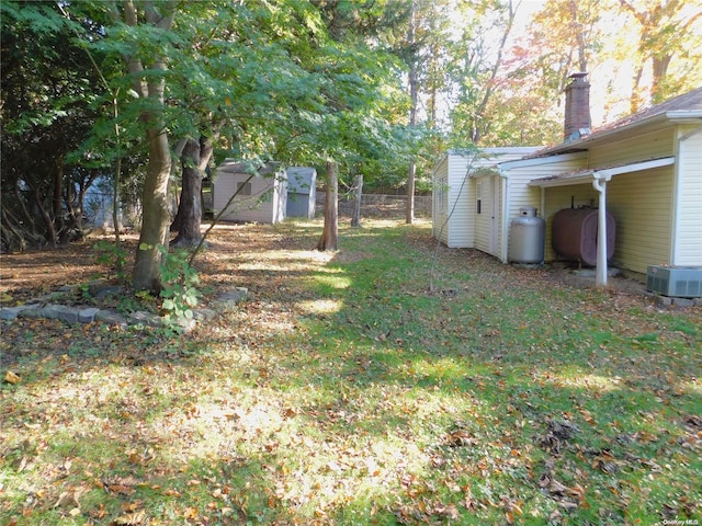 view of yard with a storage unit and central air condition unit