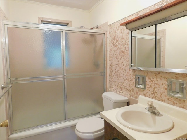 bathroom with a shower with shower door, toilet, ornamental molding, and vanity