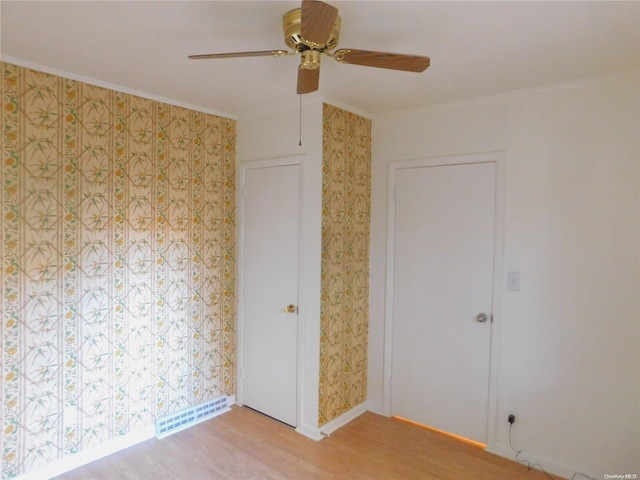 unfurnished bedroom featuring ceiling fan, ornamental molding, and light wood-type flooring