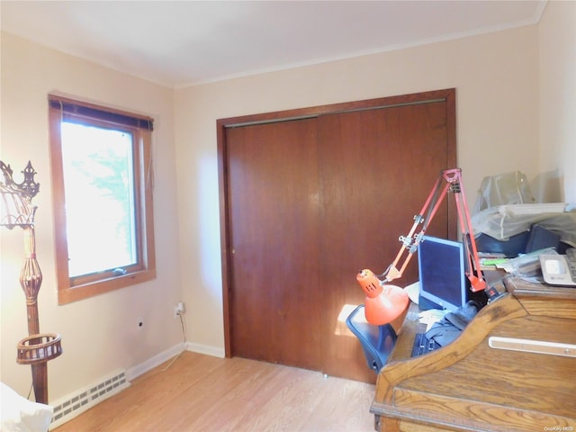 office featuring light hardwood / wood-style floors, baseboard heating, and crown molding