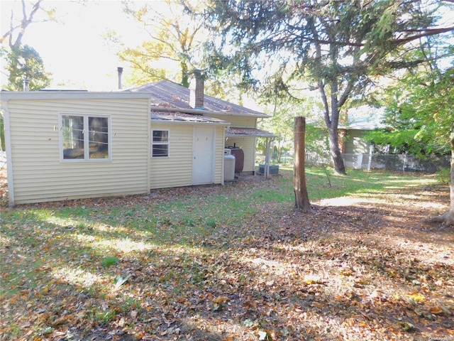 back of house featuring a yard and cooling unit