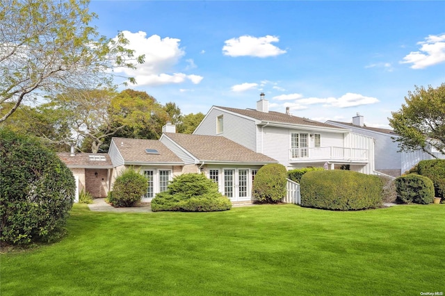 rear view of property featuring a yard and french doors