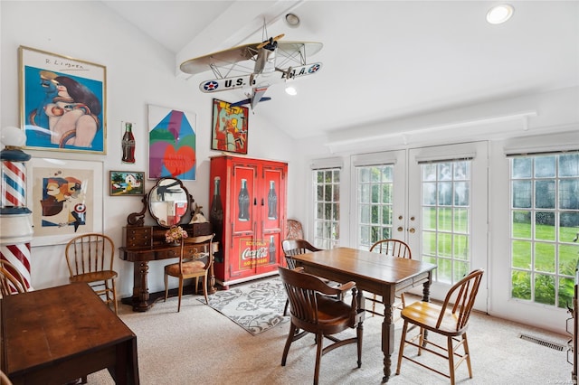 dining space with french doors, light colored carpet, and lofted ceiling