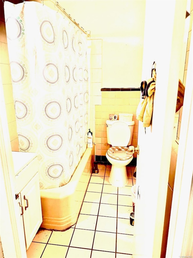 bathroom featuring tile patterned flooring, toilet, tile walls, and shower / bath combo with shower curtain