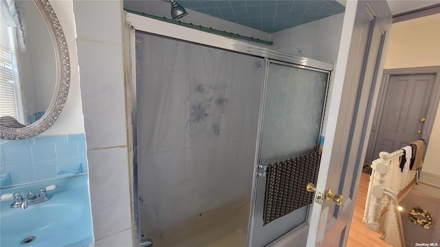 bathroom with sink, wood-type flooring, and a shower with door