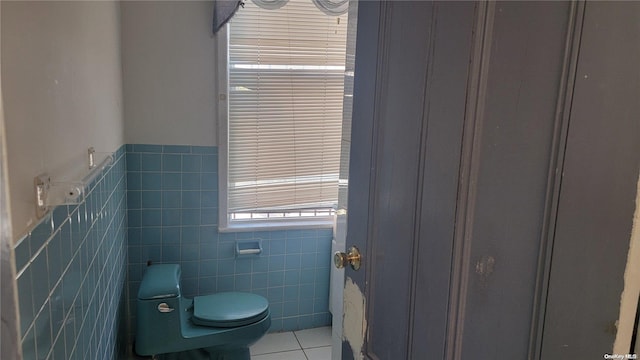 bathroom featuring tile patterned floors, toilet, and tile walls