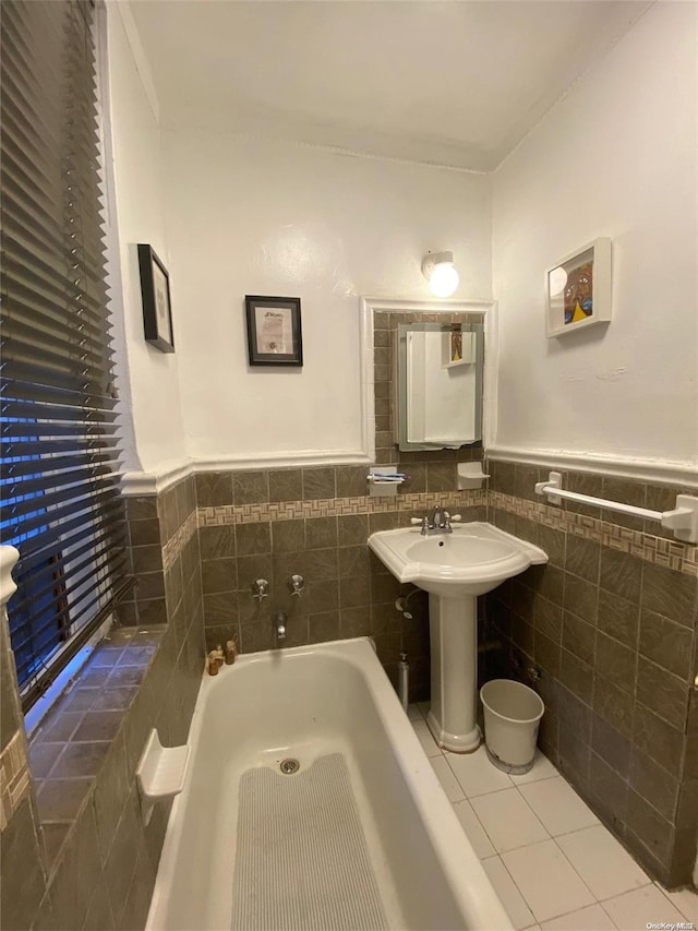 bathroom with tile patterned flooring, a bathing tub, and tile walls