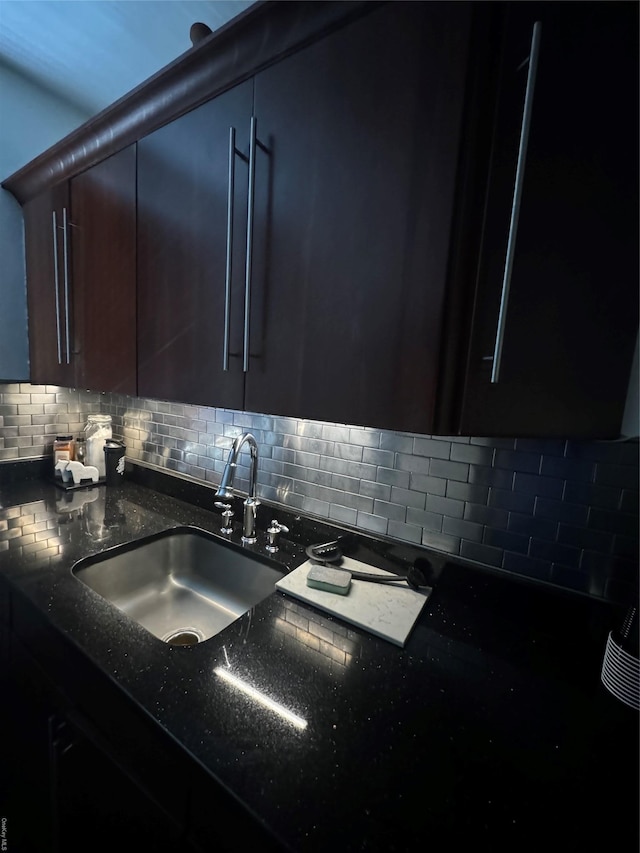 kitchen with sink, decorative backsplash, and dark stone countertops