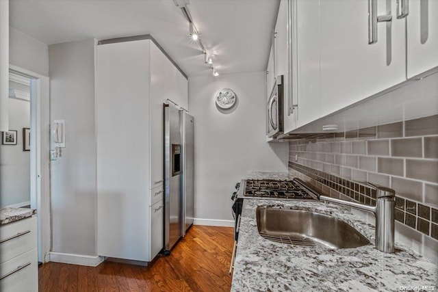 kitchen with white cabinets, dark hardwood / wood-style floors, backsplash, and appliances with stainless steel finishes