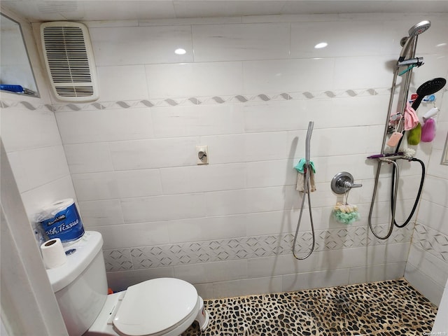 bathroom featuring tiled shower and toilet