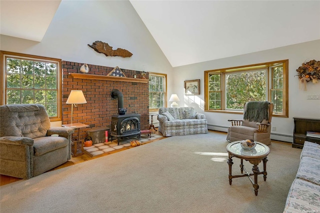 living room featuring a healthy amount of sunlight, light colored carpet, a wood stove, and a baseboard heating unit