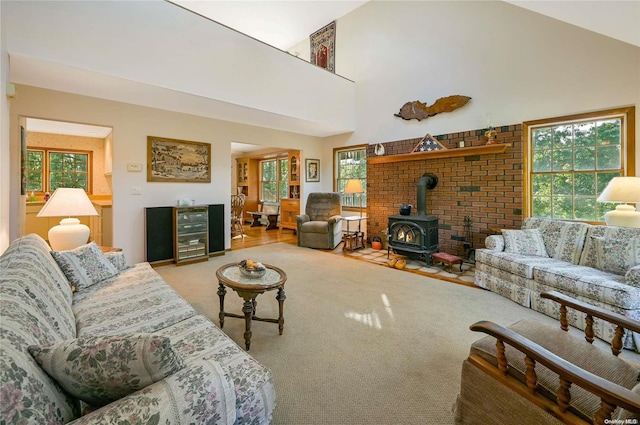 living room featuring hardwood / wood-style flooring, beverage cooler, a wood stove, and high vaulted ceiling