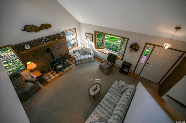 living room with a wood stove and lofted ceiling