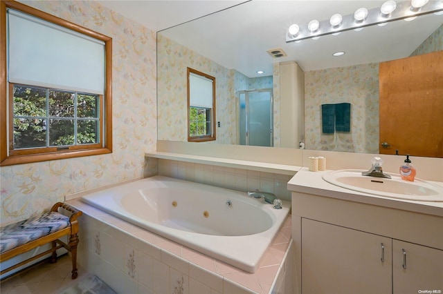 bathroom with tile patterned floors, vanity, and shower with separate bathtub