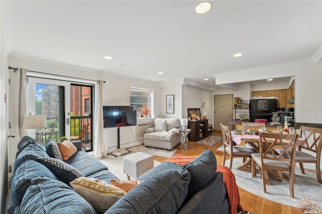 living room featuring crown molding and light hardwood / wood-style flooring