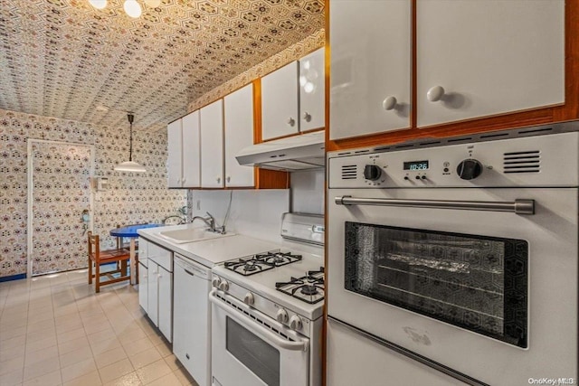 kitchen with white cabinetry, sink, decorative light fixtures, and white appliances