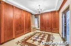 interior space featuring a notable chandelier, a raised ceiling, and french doors