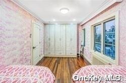 bedroom with hardwood / wood-style floors and ornamental molding