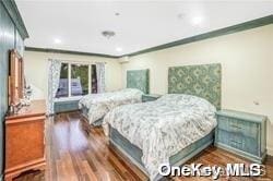 bedroom featuring ornamental molding and dark wood-type flooring