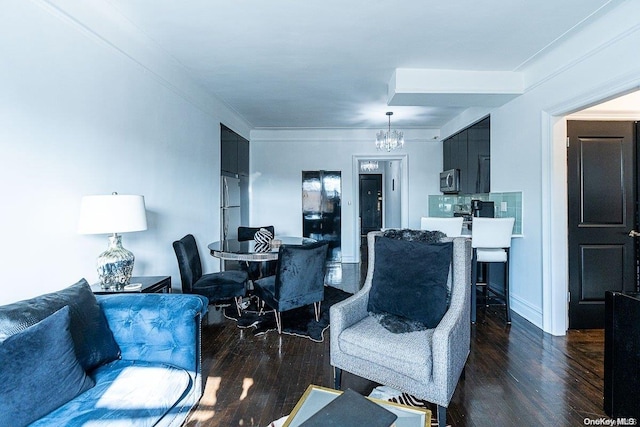 living room with dark hardwood / wood-style flooring, ornamental molding, and a chandelier