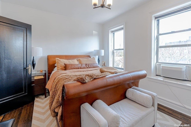 bedroom featuring dark hardwood / wood-style floors, a chandelier, and multiple windows