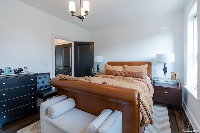 bedroom with dark hardwood / wood-style floors and a chandelier