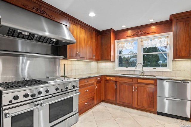 kitchen featuring light stone counters, sink, extractor fan, and appliances with stainless steel finishes