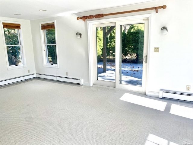 spare room featuring light colored carpet and a baseboard heating unit