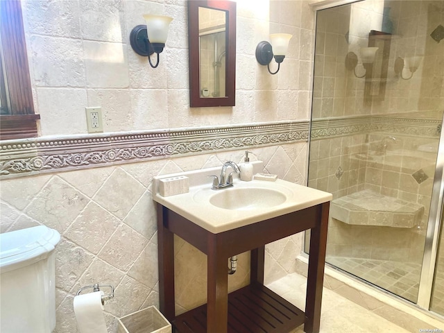 bathroom with sink, a shower with door, tile walls, and toilet