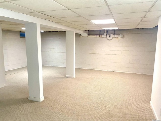 basement featuring carpet flooring and a drop ceiling