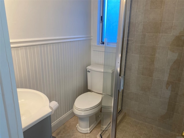 bathroom featuring tile patterned floors, vanity, a shower with shower door, and toilet