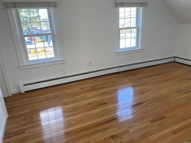 bonus room featuring a baseboard radiator, lofted ceiling, and light hardwood / wood-style floors