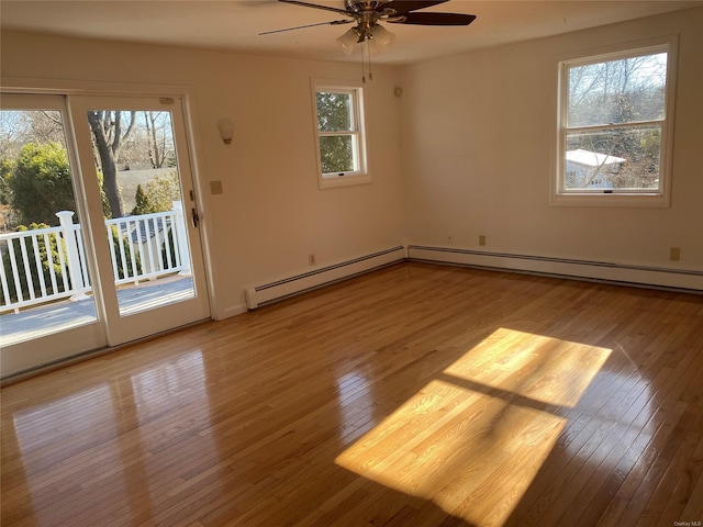 spare room with ceiling fan, a baseboard radiator, and light hardwood / wood-style flooring