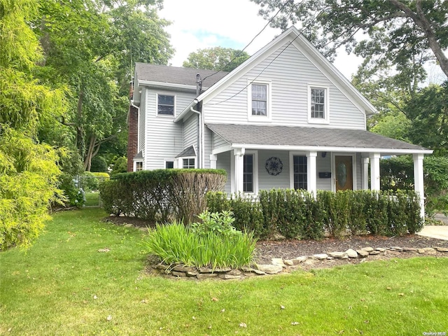 view of front of home with a porch and a front lawn