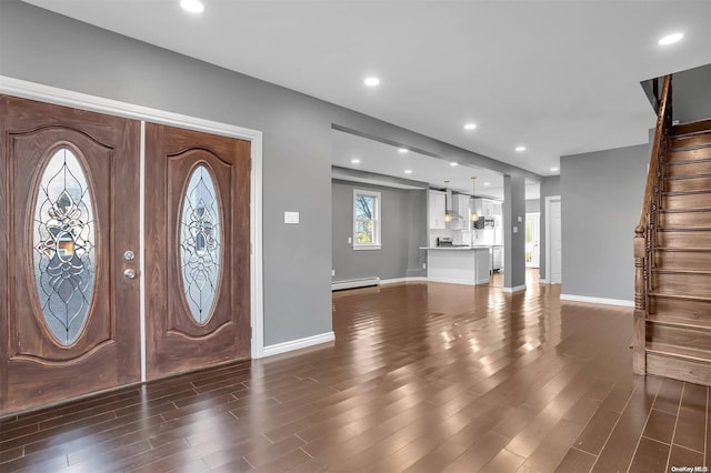 entrance foyer with dark hardwood / wood-style floors, a barn door, and a baseboard radiator