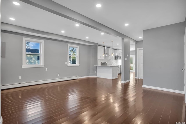 unfurnished living room featuring dark hardwood / wood-style floors and a baseboard heating unit