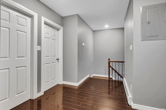 hall featuring dark hardwood / wood-style floors, electric panel, and a baseboard radiator